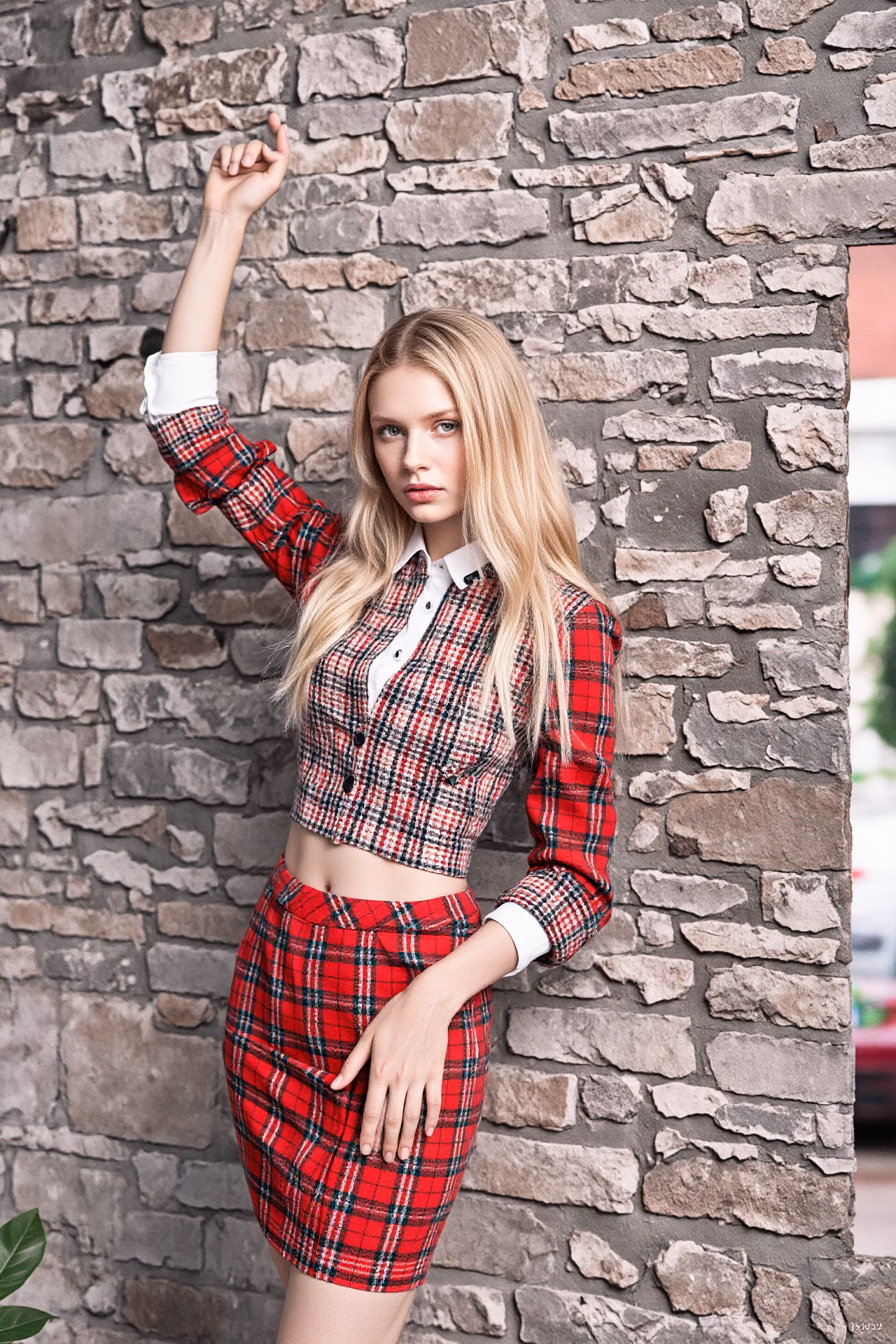 Close-up portrait of a young British woman with blonde hair and pink lips in fashionable attire, expressing love and charm.