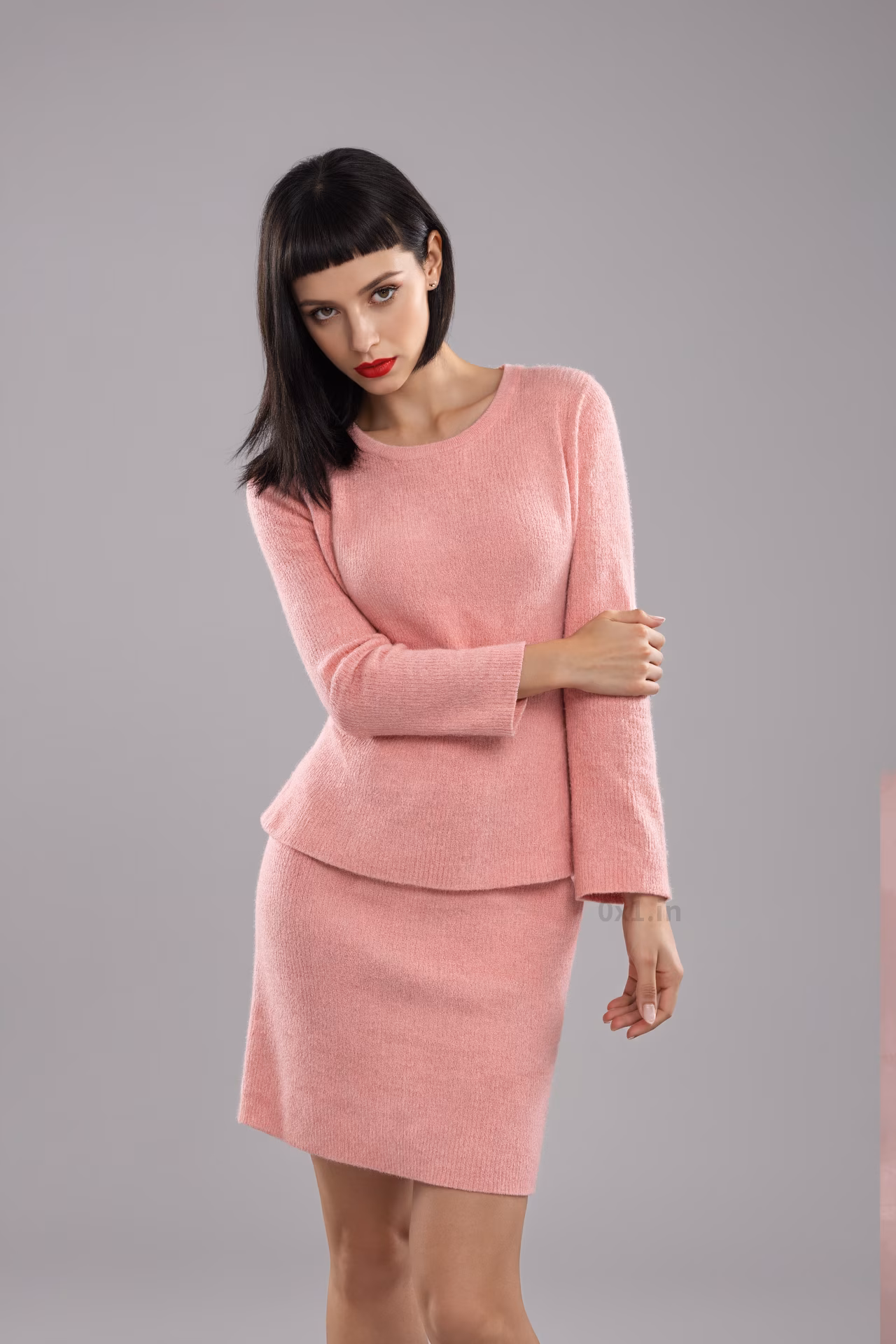 Close-up portrait of a content tall Romanian woman with brown eyes and red lips in a bodycon dress in an office setting.