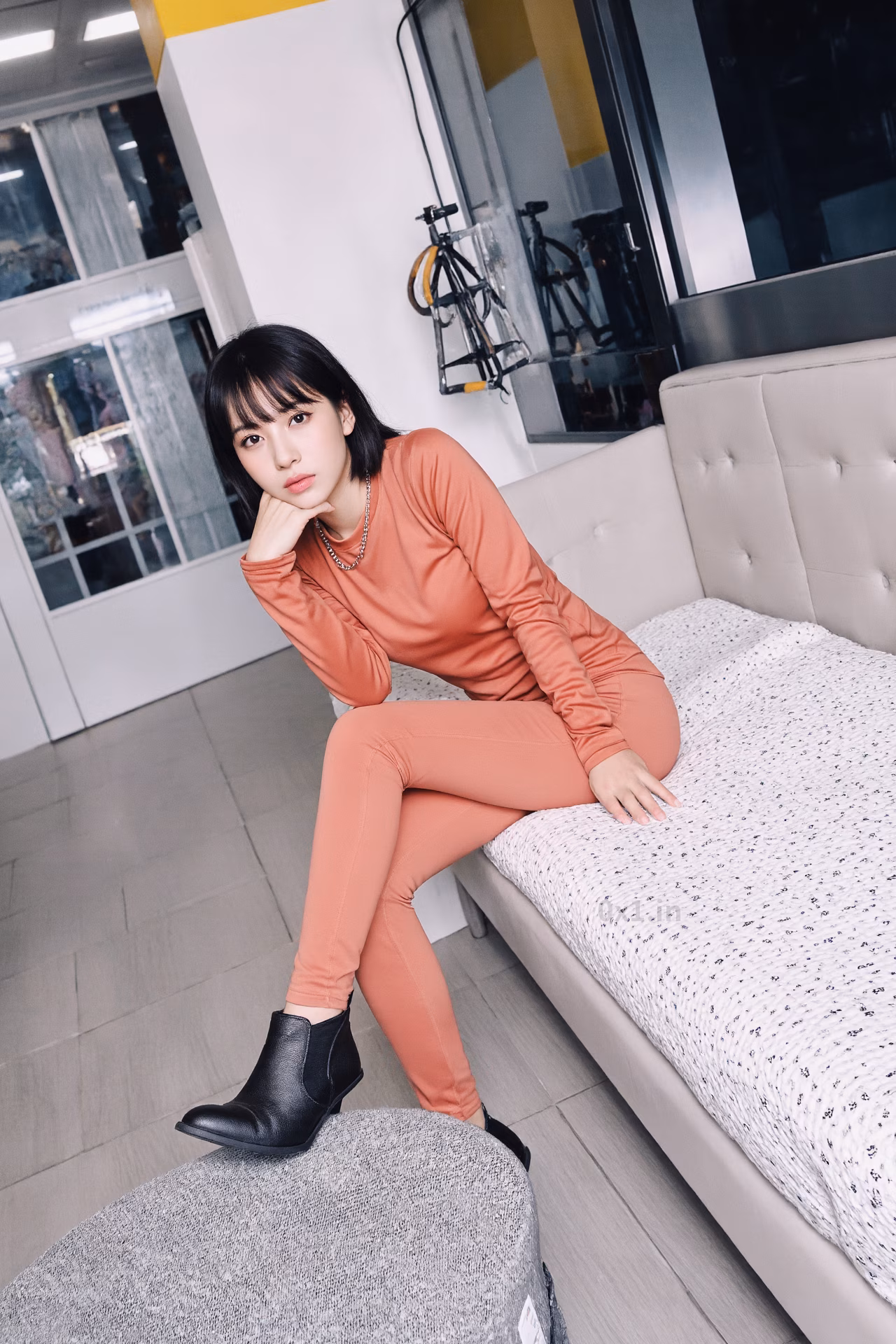 Close-up portrait of a 26-year-old slim Japanese woman with brown eyes and pink lips, smiling in stylish winter attire.