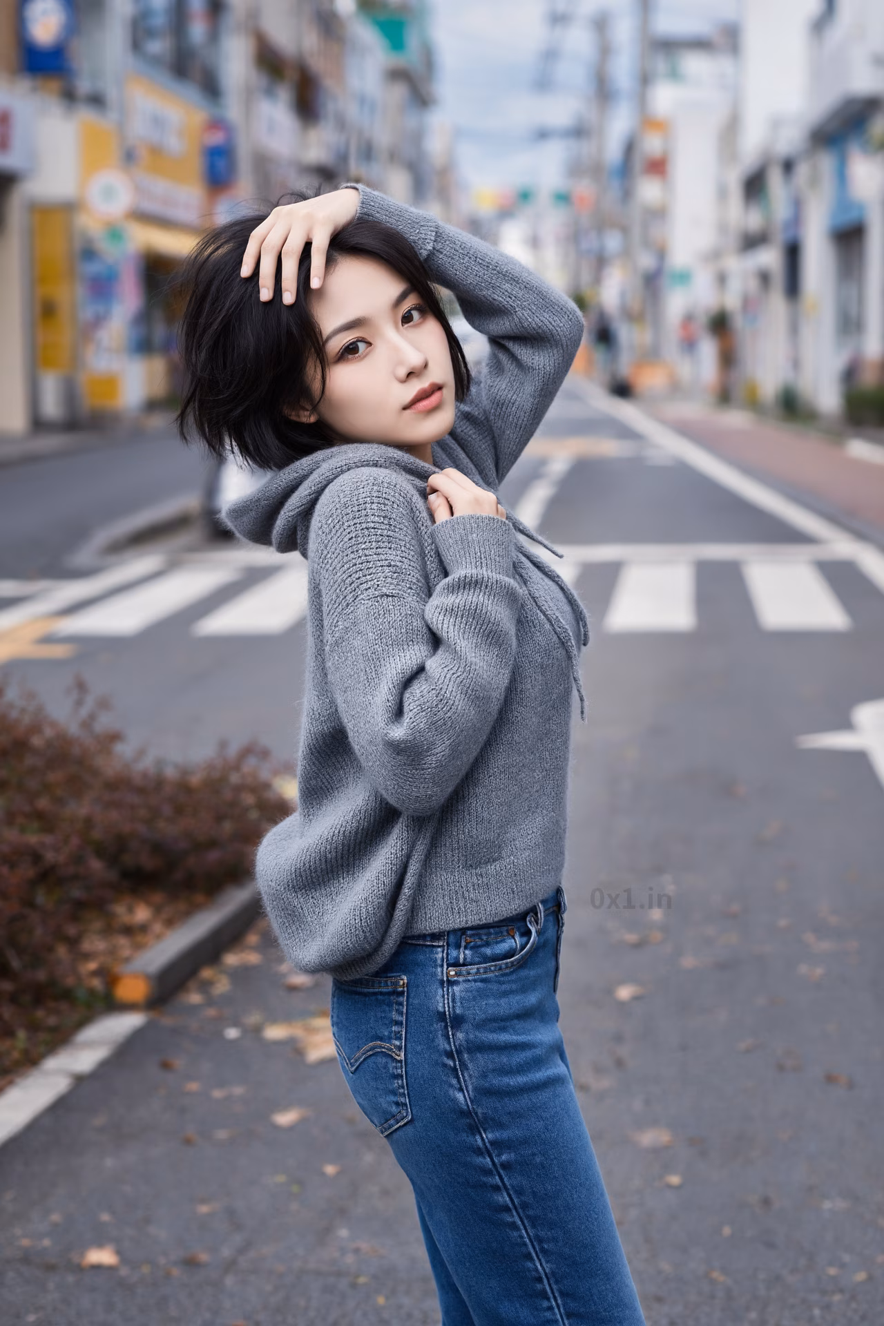 Close-up portrait of a slim Japanese woman wearing an oversized hoodie and bootcut jeans, surrounded by a Japanese street backdrop.