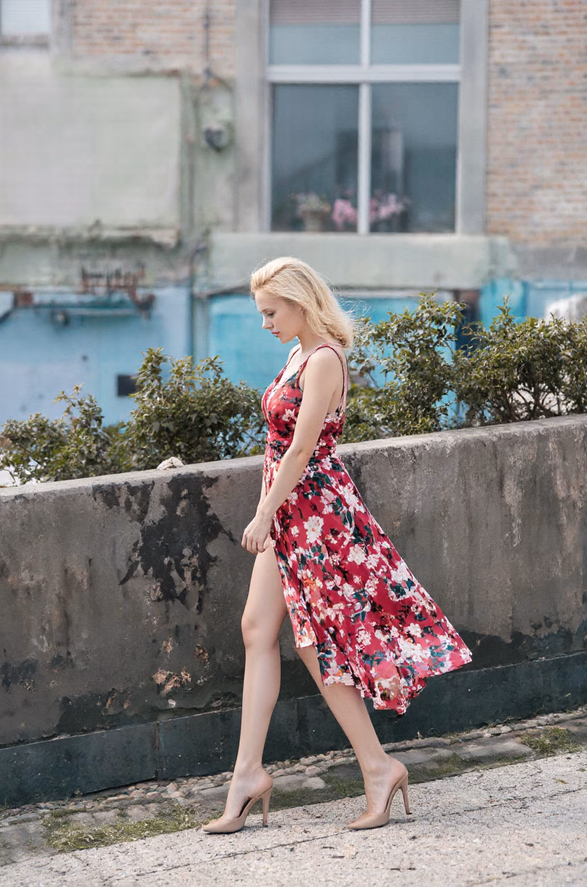 Albanian woman in a floral maxi dress, showcasing her blue eyes and ballerina bun hairstyle in various settings.