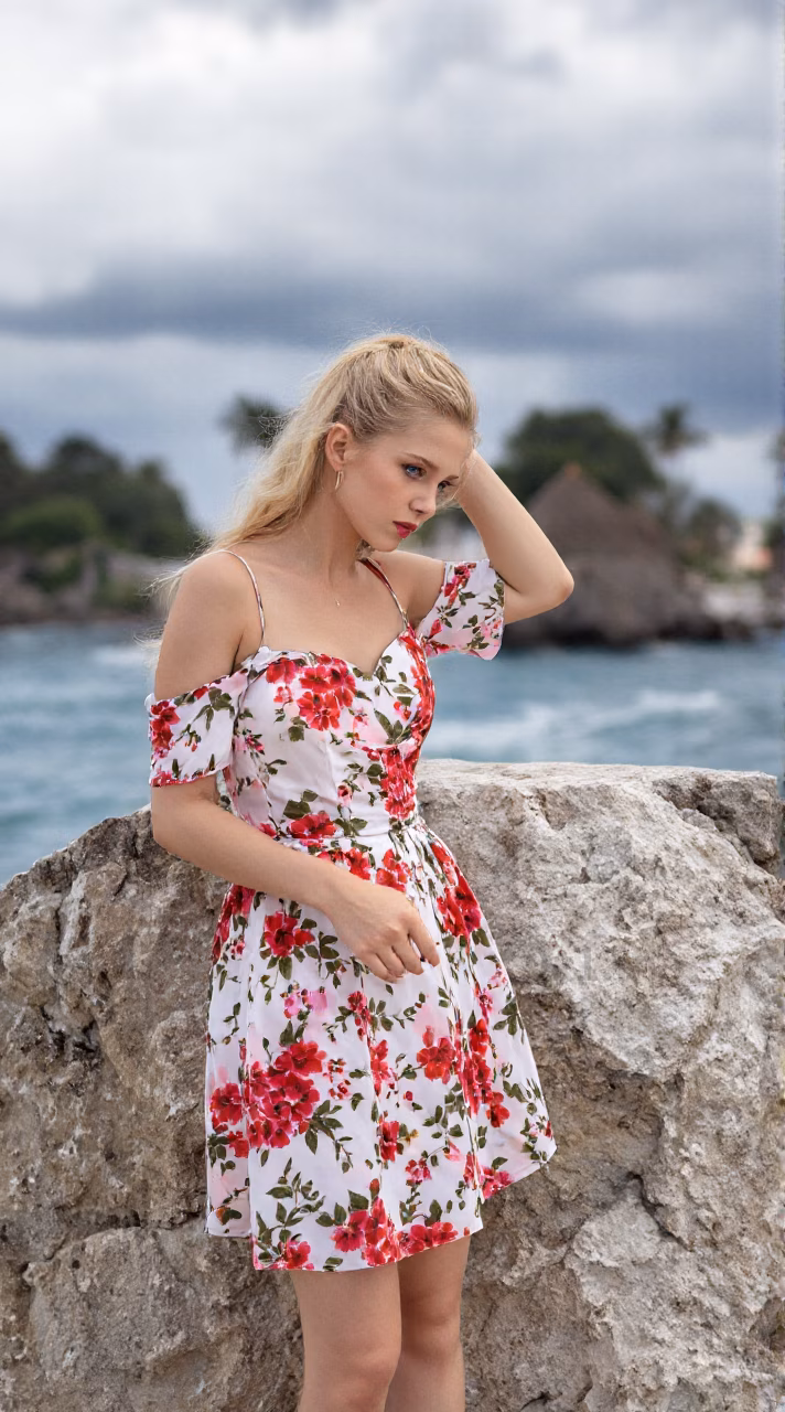 Albanian woman in a floral maxi dress, showcasing her blue eyes and ballerina bun hairstyle in various settings.